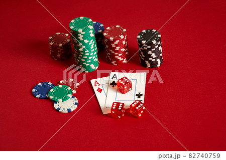 Poker chips and aces on red background. Group of different poker chips. Casino background. Poker chips and aces on red background. Group of different poker chips. Casino background. 82740759