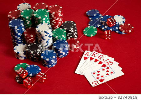 Casino gambling poker equipment and entertainment concept - close up of playing cards and chips at red background. Royal flush heart. Casino gambling poker equipment and entertainment concept - close up of playing cards and chips at red background. Royal flush heart. 82740818