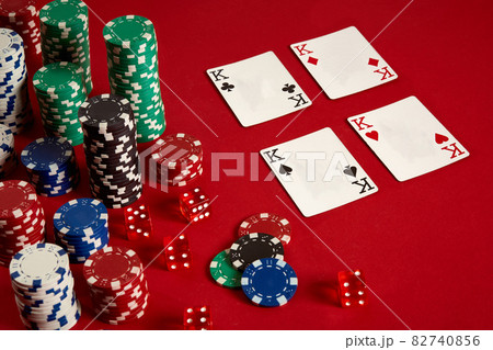 Casino gambling poker equipment and entertainment concept - close up of playing cards and chips at red background. Four of a Kind Casino gambling poker equipment and entertainment concept - close up of playing cards and chips at red background. Four of a Kind 82740856