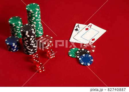 Poker chips and aces on red background. Group of different poker chips. Casino background. 82740887