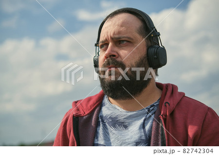 Middle aged man listening to music, close up 82742304