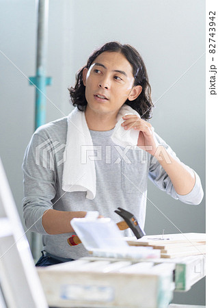 建築現場で汗を拭う若い男性のポートレート 建築現場で汗を拭う若い男性のポートレート 82743942