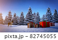 reindeer looks at christmas gift boxes on snowy ground with pine trees in background 82745055