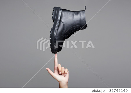 woman's hand holding Black boot. fashion shoes woman's hand holding Black boot. fashion shoes 82745149