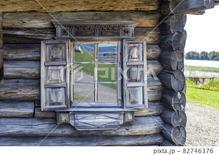 Platbands and shutters are decorated with traditional Russian northern carvings. House of the Oshevnev peasants from Zaonezh. Kizhi Island. Republic of Karelia. Russia Platbands and shutters are decorated with traditional Russian northern carvings. House of the Oshevnev peasants from Zaonezh. Kizhi Island. Republic of Karelia. Russia 82746376