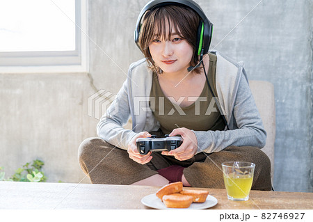 部屋でネットゲーム（オンラインゲーム）をプレイする女性 82746927