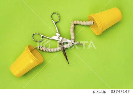 Plastic can phones on green background with the cord got cut off Plastic can phones on green background with the cord got cut off 82747147