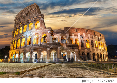 Illuminated Roman Coliseum under the clouds at sunrise, Italy 82747897