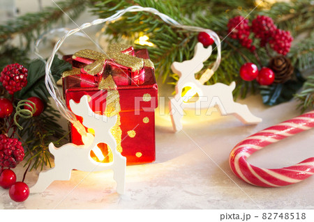 Winter Christmas background with fir branches, gifts and new year's garland. Winter Christmas background with fir branches, gifts and new year's garland. 82748518
