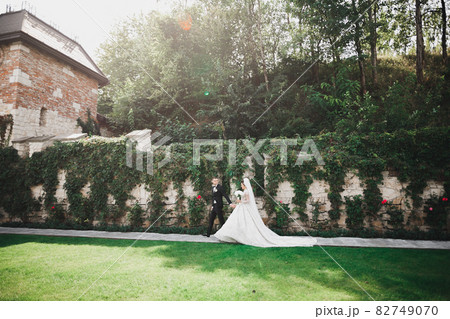 Happy wedding couple walking in a botanical park 82749070