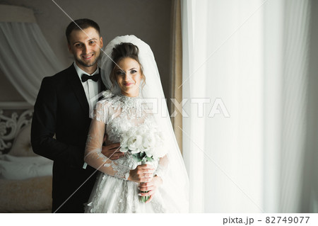 Romantic wedding moment, couple of newlyweds smiling portrait, bride and groom hugging 82749077