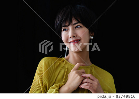ショートヘアの若い女性 黒バックの写真素材