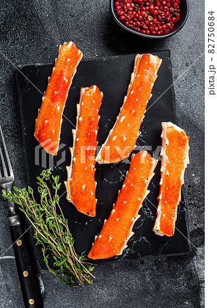 Crab legs Phalanx on a marble board with thyme. Black background. Top view Crab legs Phalanx on a marble board with thyme. Black background. Top view 82750684