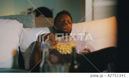 Sleepy black man watching match at night 82751341