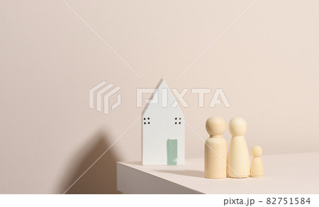 wooden family figurines, model house on a beige background. Real estate purchase, rental concept. Moving to new apartments 82751584