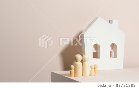 wooden family figurines, model house on a beige background. Real estate purchase, rental concept. Moving to new apartments 82751585
