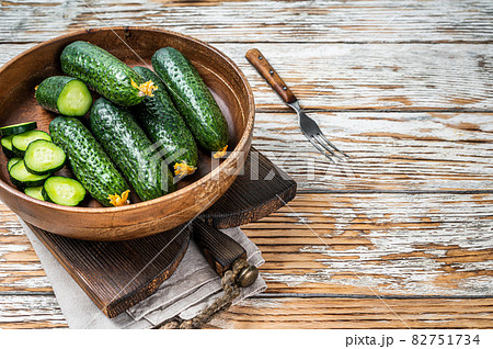 Raw organic Cucumbers in a wooden plate. White Wooden background. Top view. Copy space 82751734