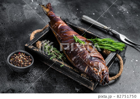 Hot smoked pike perch or zander fish in a wooden tray. Black background. Top view Hot smoked pike perch or zander fish in a wooden tray. Black background. Top view 82751750