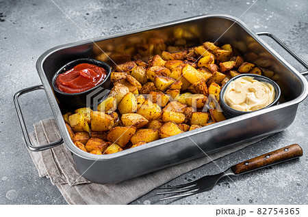 Patatas bravas traditional Spanish potatoes snack tapas in a steel tray. Gray background. Top view 82754365