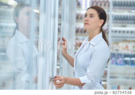 Woman looking closely at pharmacy shelves 82754538