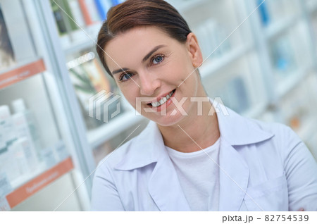 Happy woman near shelves with medicines Happy woman near shelves with medicines 82754539