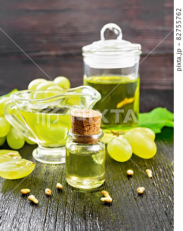 Oil grape in vial on dark wooden board Oil grape in vial on dark wooden board 82755762