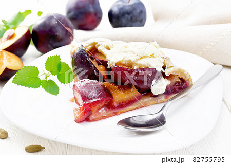 Galeta with plums in plate on white wooden board 82755795