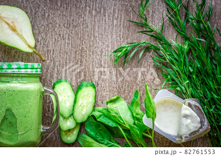 Healthy green smoothie with spinach in a mug against on wooden background 82761553
