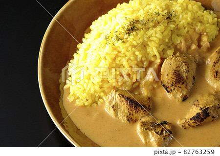 鶏肉がゴロゴロと入っているタンドリーチキンバターカレーを黒背景で俯瞰撮影 82763259