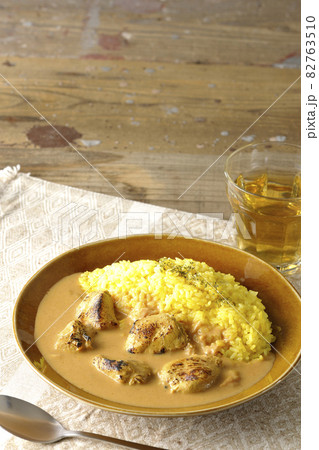 ランチョンマットに置かれたお肉ゴロゴロタンドリーチキンバターカレーとお茶 82763510