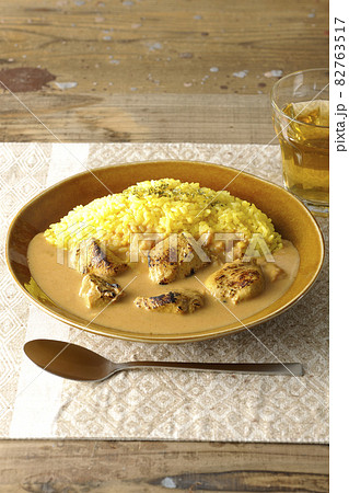 ランチョンマットに置かれたお肉ゴロゴロタンドリーチキンバターカレーとお茶 ランチョンマットに置かれたお肉ゴロゴロタンドリーチキンバターカレーとお茶 82763517