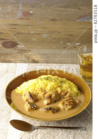 ランチョンマットに置かれたお肉ゴロゴロタンドリーチキンバターカレーとお茶 ランチョンマットに置かれたお肉ゴロゴロタンドリーチキンバターカレーとお茶 82763518
