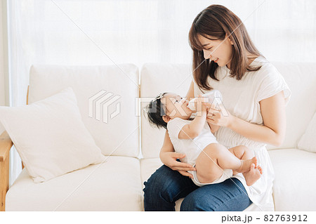 赤ちゃんに哺乳瓶でミルクをあげるお母さん 赤ちゃんに哺乳瓶でミルクをあげるお母さん 82763912