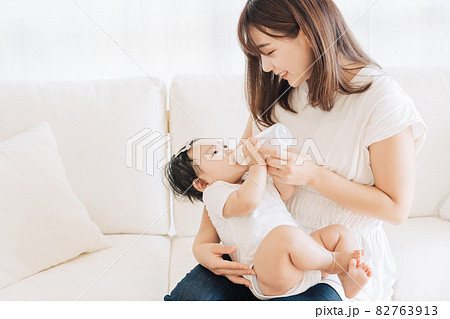 赤ちゃんに哺乳瓶でミルクをあげるお母さん 82763913