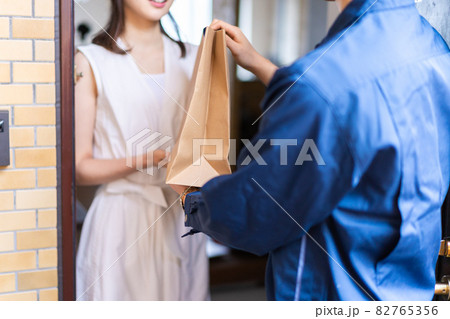 フードデリバリーを受け取る若い女性 82765356