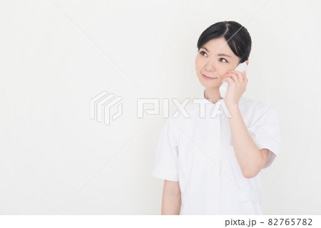 電話をする看護師の女性 電話をする看護師の女性 82765782