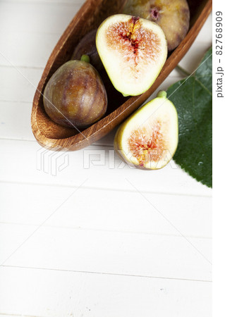 Figs in a wooden plate with leaves 82768909
