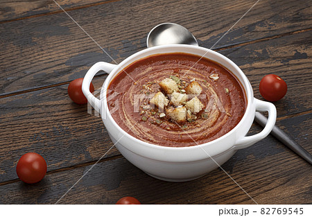 Bowl of tomato soup on wooden background 82769545