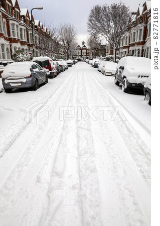 street winter cityscape with snow terraced houses and frozen cars after a blizzard snowfall, 82771816