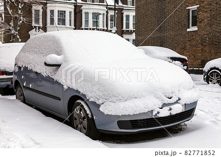 street winter cityscape with snow covered frozen cars after a blizzard snowfall 82771852