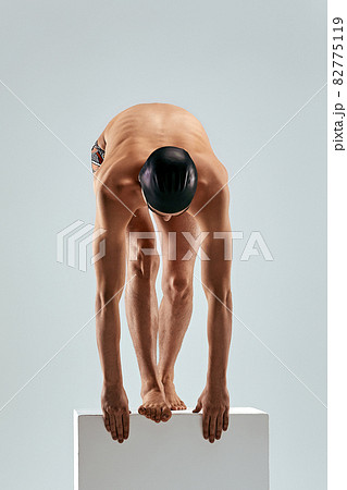 Portrait of a swimmer who is preparing for a jump. The concept of swimming and water games. Front view. Mixed media Portrait of a swimmer who is preparing for a jump. The concept of swimming and water games. Front view. Mixed media 82775119