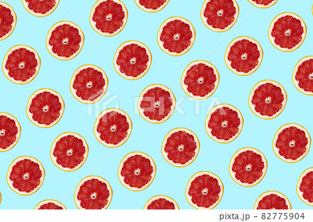 Fresh grapefuit slices seamless pattern over blue background, top view 82775904