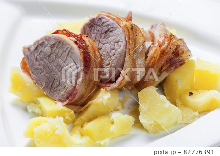 pork roll wrapped in bacon with potatoes 82776391