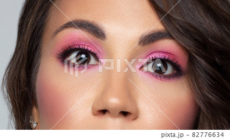 Beautiful macro of expressive brown eyes with fashionable pink smoky shadows, extremely long eyelashes. Cosmetology, eyebrow correction, eyelash extensions, makeup, cosmetics, eyesight, contact lenses Beautiful macro of expressive brown eyes with fashionable pink smoky shadows, extremely long eyelashes. Cosmetology, eyebrow correction, eyelash extensions, makeup, cosmetics, eyesight, contact lenses 82776634