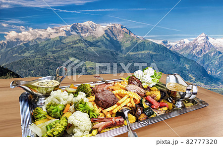 Traditional austrian food experience over Zell am see village with Kitzsteinhorn peak ( Tauern Alps) in Austria 82777320