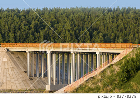 Unique concrete bridge and road against background of forest. 82778278