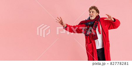 Cropped portrait of young boy, wearing scarf, warm gown isolated over pink background. Recovering from cold and flu, allergy. Flyer 82778281
