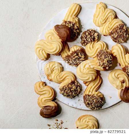 Shortcrust cookies with chocolate glaze and nuts over white. Top view 82779521