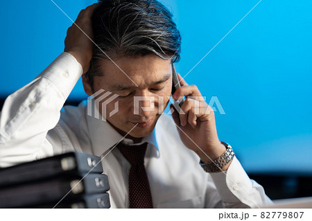 ビジネスマン　残業　ミドル男性　スマホ 82779807