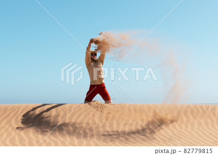 Single man throws sand in the Namib desert 82779815